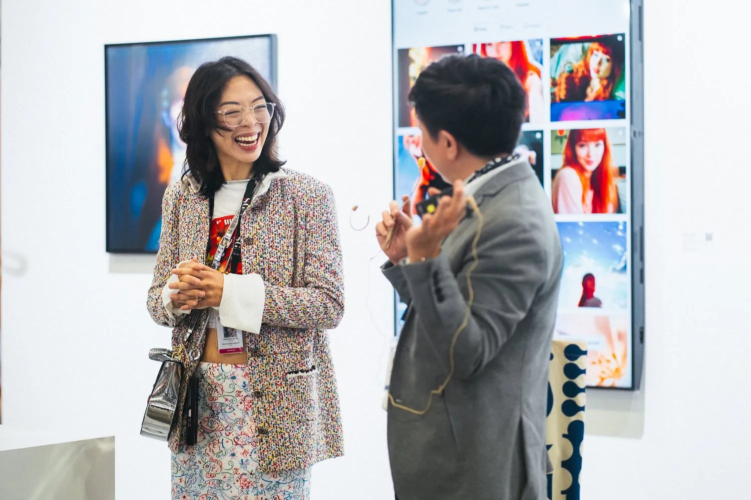 Shavonne Wong speaking to a guest at ART SG 2025 during the solo presentation of Meet Eva Here, with Eva's Instagram diary display behind.