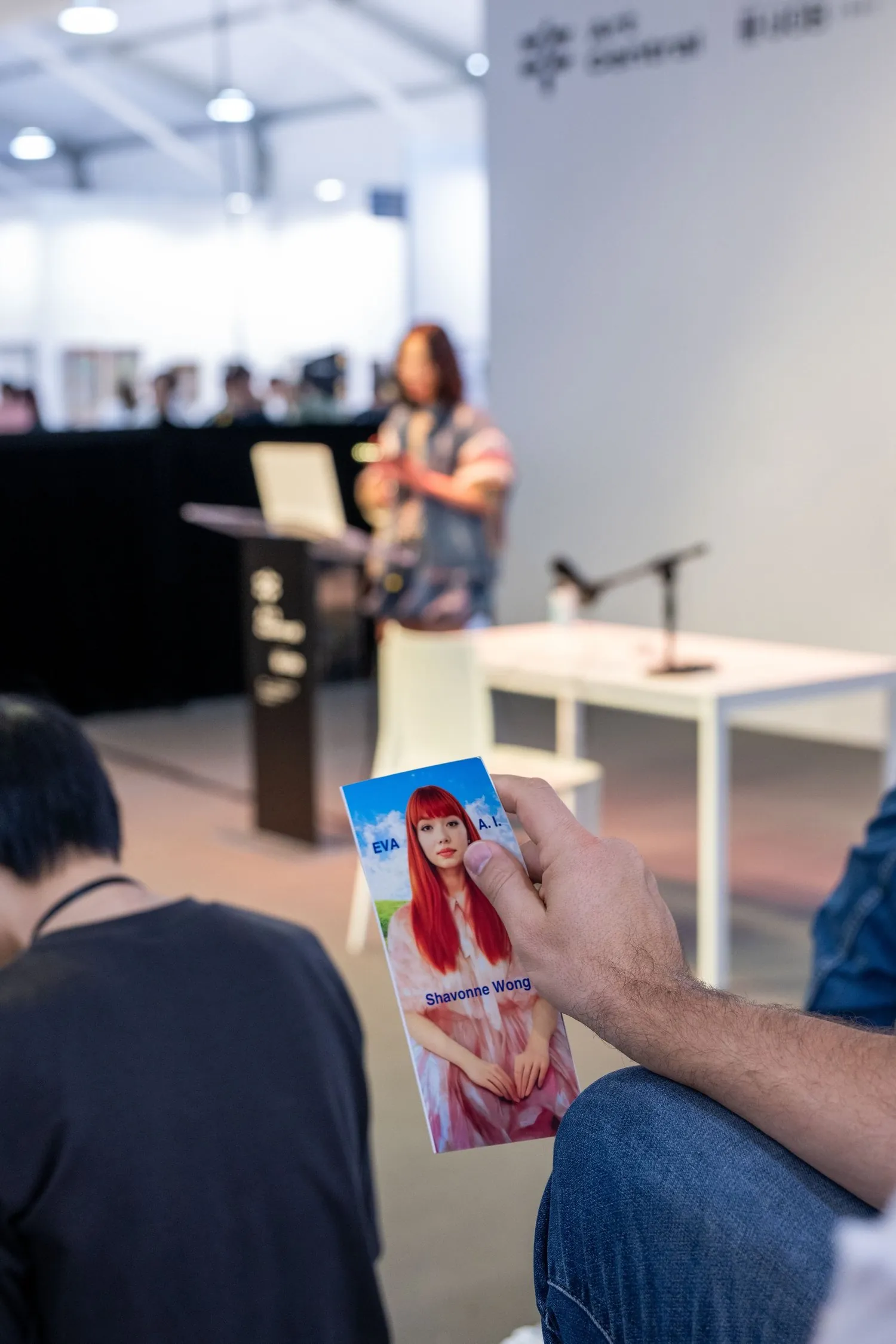 Audience member holding a brochure featuring Eva during the Art Central Hong Kong 2025 talk.