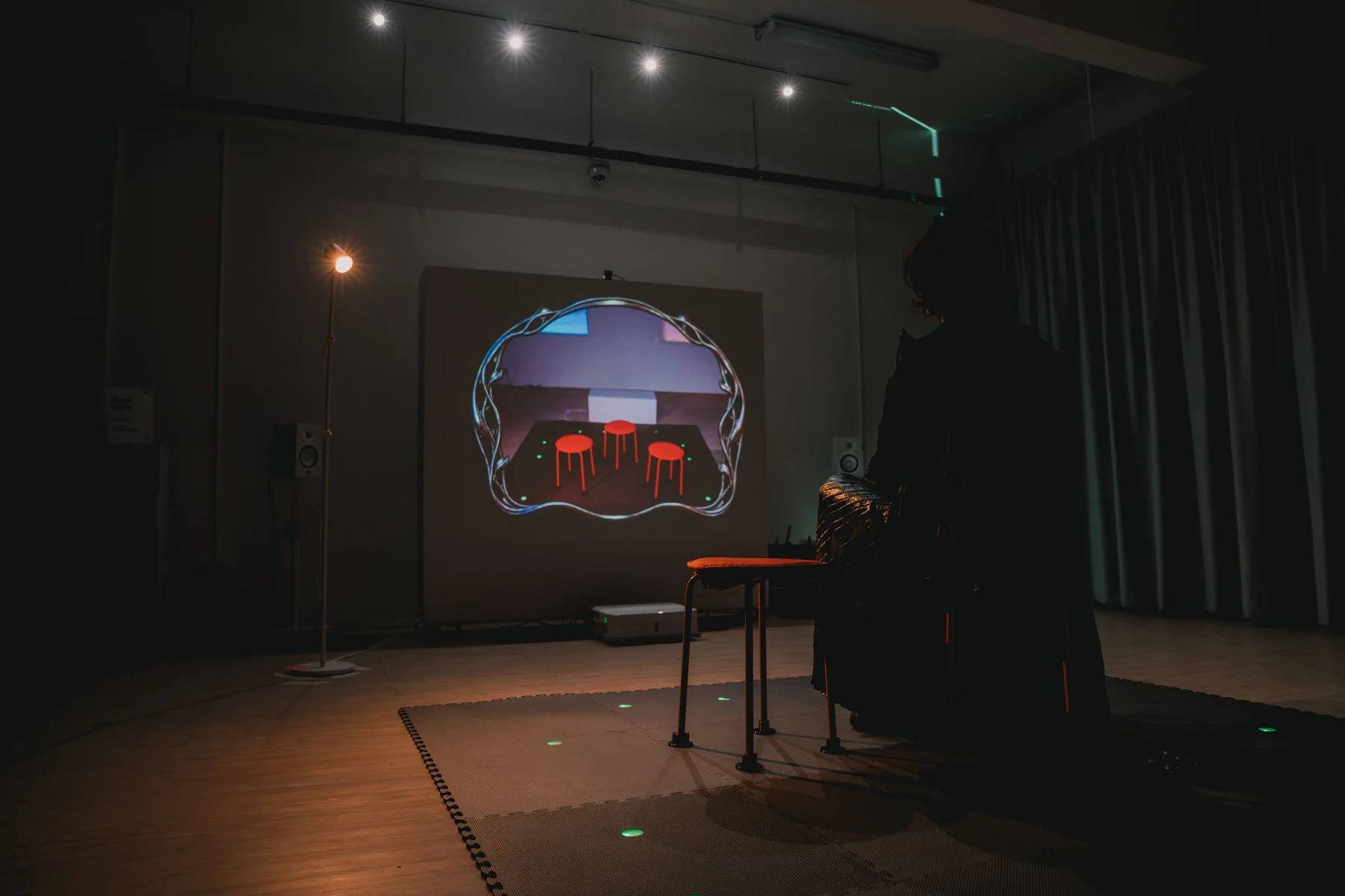 Shavonne Wong faces a projection showing the stools without her.